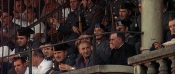 Movie still from “The Moment of Truth” (1965), directed by Francesco Rosi – A group of men sitting next to each other in a stadium; Medium shot, High angle