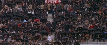 Movie still from “The Moment of Truth” (1965), directed by Francesco Rosi – A group of people sitting on top of steps under umbrellas; Extreme Wide shot, High angle