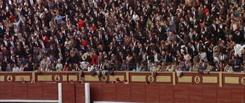 Movie still from “The Moment of Truth” (1965), directed by Francesco Rosi – A crowd of people in suits and ties watching a baseball game; Extreme Wide shot, High angle