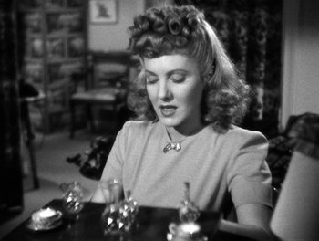 Movie still from “The More the Merrier” (1943), directed by George Stevens – A woman sitting at a table with a plate in front of her; Close Up shot, Over the shoulder angle