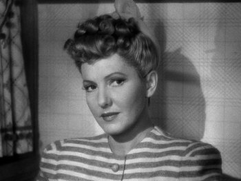 Movie still from “The More the Merrier” (1943), directed by George Stevens – An old black and white photo of a woman in a striped shirt; Close Up shot, Low angle