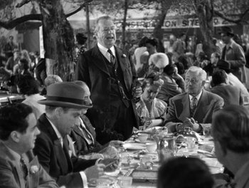 Movie still from “The More the Merrier” (1943), directed by George Stevens – A group of men sitting at a table with plates of food; Medium shot, Over the shoulder angle