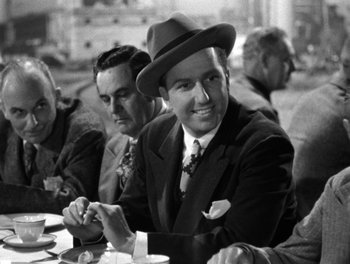 Movie still from “The More the Merrier” (1943), directed by George Stevens – Black and white photograph of men sitting at a table; Medium shot, Over the shoulder angle