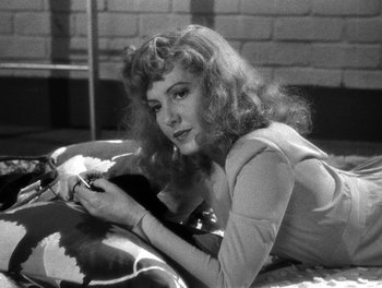 Movie still from “The More the Merrier” (1943), directed by George Stevens – A black and white photo of a woman holding a cell phone; Close Up shot, High angle
