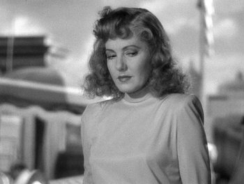 Movie still from “The More the Merrier” (1943), directed by George Stevens – An old photo of a woman in a white shirt; Close Up shot, Over the shoulder angle