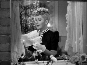 Movie still from “The More the Merrier” (1943), directed by George Stevens – An old black and white photo of a woman reading a letter; Medium shot, Over the shoulder angle
