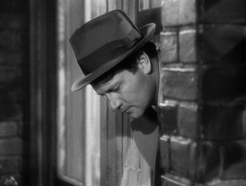 Movie still from “The More the Merrier” (1943), directed by George Stevens – A black and white photo of a man wearing a hat; Close Up shot, High angle