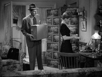 Movie still from “The More the Merrier” (1943), directed by George Stevens – A man and a woman standing in a room; Medium shot, High angle