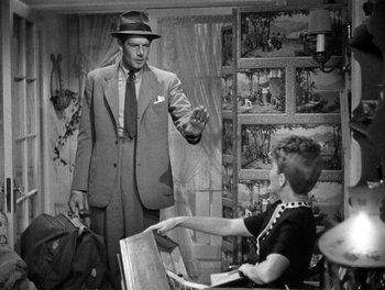 Movie still from “The More the Merrier” (1943), directed by George Stevens – An old photo of a man and a woman; Medium shot, Over the shoulder angle