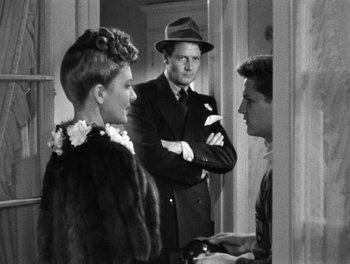 Movie still from “The More the Merrier” (1943), directed by George Stevens – A group of people standing around each other in a room; Medium shot, Over the shoulder angle