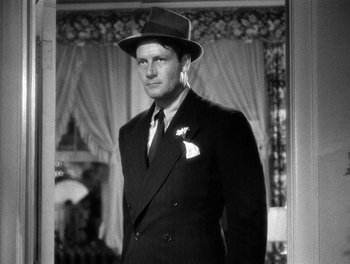 Movie still from “The More the Merrier” (1943), directed by George Stevens – A black and white photo of a man in a suit and hat; Close Up shot, Low angle