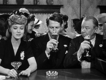 Movie still from “The More the Merrier” (1943), directed by George Stevens – A group of people sitting at a table drinking wine; Medium shot, High angle