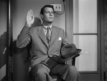 Movie still from “The More the Merrier” (1943), directed by George Stevens – A black and white photo of a man sitting in a chair; Medium shot, Low angle