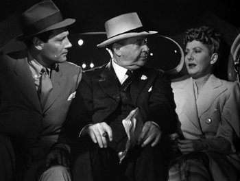 Movie still from “The More the Merrier” (1943), directed by George Stevens – A group of men sitting next to each other on a bench; Medium shot, High angle