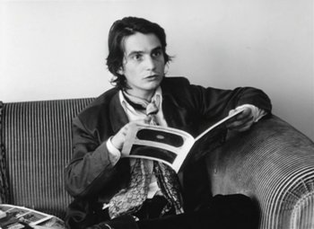 Movie still from “The Mother and the Whore” (1973), directed by Jean Eustache – A man sitting on top of a couch reading a magazine; Close Up shot, High angle