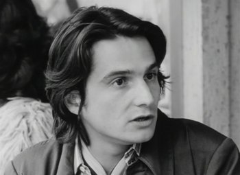 Movie still from “The Mother and the Whore” (1973), directed by Jean Eustache – Black and white photograph of a man with long hair; Close Up shot, Low angle