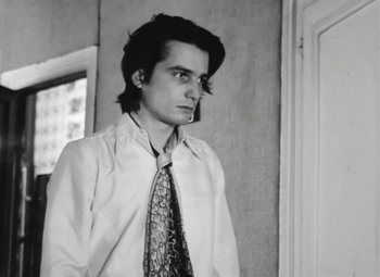 Movie still from “The Mother and the Whore” (1973), directed by Jean Eustache – A young man in a white dress shirt and tie; Close Up shot, Low angle