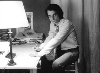 Movie still from “The Mother and the Whore” (1973), directed by Jean Eustache – A man sitting at a desk in front of a lamp; Medium shot, High angle