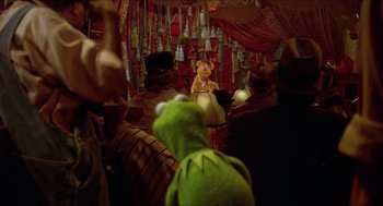 Movie still from “The Muppet Movie” (1979), directed by James Frawley – Kermit the frog and miss piggy in a scene from the muppet show; Wide shot, Over the shoulder angle