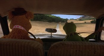 Movie still from “The Muppet Movie” (1979), directed by James Frawley – A couple of stuffed animals sitting in the drivers seat of a car; Medium shot, High angle