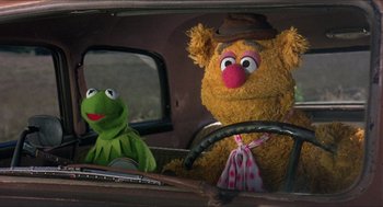 Movie still from “The Muppet Movie” (1979), directed by James Frawley – A green and a brown stuffed animal sitting in a car; Close Up shot, High angle