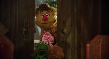 Movie still from “The Muppet Movie” (1979), directed by James Frawley – A couple of stuffed animals sitting on top of a wooden door; Medium shot, Over the shoulder angle