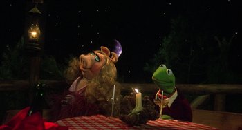 Movie still from “The Muppet Movie” (1979), directed by James Frawley – A couple of puppets sitting on top of a table next to candles; Medium shot, Low angle