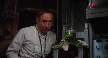 Movie still from “The Muppet Movie” (1979), directed by James Frawley – A man in a white lab coat standing in front of a puppet; Medium shot, Low angle