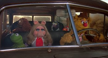 Movie still from “The Muppet Movie” (1979), directed by James Frawley – A group of stuffed animals sitting in the back seat of a car; Wide shot, High angle