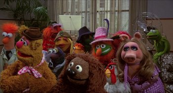 Movie still from “The Muppet Movie” (1979), directed by James Frawley – A group of stuffed animals that are sitting in a room; Wide shot, High angle