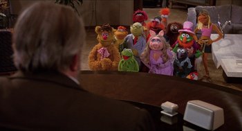 Movie still from “The Muppet Movie” (1979), directed by James Frawley – A group of stuffed animals sitting in front of a man; Wide shot, High angle