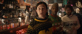 Movie still from “The Night Before” (2015), directed by Jonathan Levine – A woman wearing a yellow and black sweater and a man wearing a green and red sweater; Medium shot, Over the shoulder angle