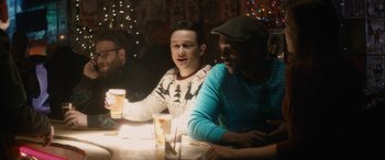 Movie still from “The Night Before” (2015), directed by Jonathan Levine – A group of people sitting at a table with drinks; Medium shot, Over the shoulder angle