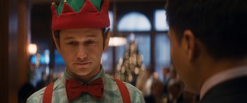 Movie still from “The Night Before” (2015), directed by Jonathan Levine – A man wearing a red and green hat and a red bow tie; Close Up shot, Over the shoulder angle