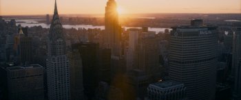 Movie still from “The Night Before” (2015), directed by Jonathan Levine – The sun is setting over a city skyline; Extreme Wide shot, High angle