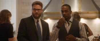 Movie still from “The Night Before” (2015), directed by Jonathan Levine – A couple of men standing next to each other; Medium shot, Over the shoulder angle