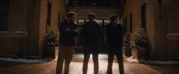 Movie still from “The Night Before” (2015), directed by Jonathan Levine – A group of men standing next to each other on a sidewalk; Wide shot, Over the shoulder angle