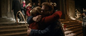 Movie still from “The Night Before” (2015), directed by Jonathan Levine – A man and a woman hugging each other in front of a crowd of onlookers; Medium shot, Over the shoulder angle