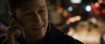 Movie still from “The Night Before” (2015), directed by Jonathan Levine – A person smiling with lights in the background; Close Up shot, Over the shoulder angle