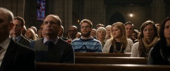 Movie still from “The Night Before” (2015), directed by Jonathan Levine – A group of people sitting in a row of pews; Medium shot, Over the shoulder angle
