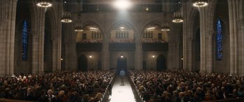 Movie still from “The Night Before” (2015), directed by Jonathan Levine – A man standing in front of an audience in a church; Extreme Wide shot, High angle