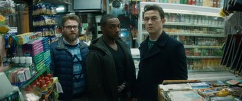 Movie still from “The Night Before” (2015), directed by Jonathan Levine – A group of men standing next to each other in a store; Medium shot, Over the shoulder angle