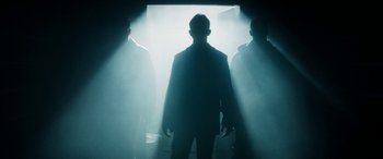 Movie still from “The Night Before” (2015), directed by Jonathan Levine – A man standing in the middle of a dark room; Medium shot, Low angle