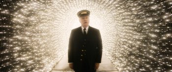 Movie still from “The Night Before” (2015), directed by Jonathan Levine – A man in a suit and hat standing in front of lights; Medium shot, Low angle