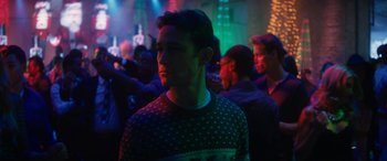 Movie still from “The Night Before” (2015), directed by Jonathan Levine – A young man in a christmas sweater in a crowd of people; Close Up shot, Over the shoulder angle