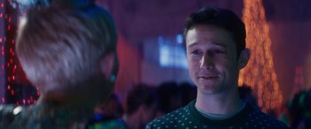 Movie still from “The Night Before” (2015), directed by Jonathan Levine – A man in a green sweater is smiling at the camera; Close Up shot, Over the shoulder angle