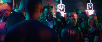 Movie still from “The Night Before” (2015), directed by Jonathan Levine – A group of people standing in a room at a party; Medium shot, Over the shoulder angle