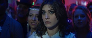 Movie still from “The Night Before” (2015), directed by Jonathan Levine – A woman with blue eyes is looking at the camera; Close Up shot, Over the shoulder angle