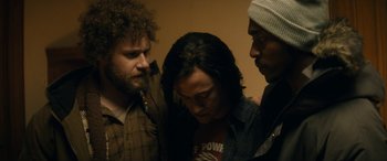 Movie still from “The Night Before” (2015), directed by Jonathan Levine – A group of men standing next to each other in a room; Medium shot, Over the shoulder angle
