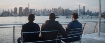 Movie still from “The Night Before” (2015), directed by Jonathan Levine – Three men sitting on a bench looking out at the city; Wide shot, Over the shoulder angle
